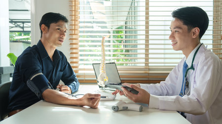 Doctor explaining anatomical spine to his patient in medical office. Medical, orthopedic and health care concept.の写真素材