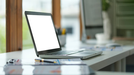 Comfortable home office. Laptop computer, stationery and potted plant on white table.の写真素材