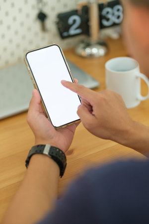 Young man holding mockup smart phone with white empty screen. Close up view.の写真素材
