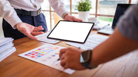 Creative designer or developer team using digital tablet working together on mobile app template design at co working space.の写真素材