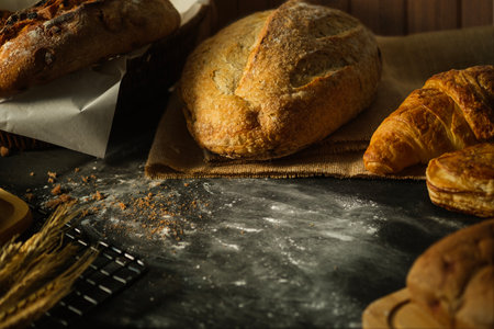 Delicious crusty loaves of bread on black wooden table. Top view with copy space.の写真素材