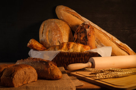 Variety of baked bread and bakery products on a wooden table.