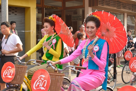 CHIANGMAI,THAILAND - APRIL 13 Thai Beautiful Lady with traditional dressed in parade ride bicycle hold umbrella on Songkran Festival  on April 13, 2014 in Chiangmai Thailand  のeditorial素材