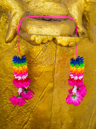 Flower plastic on your hand statue Buddha.の写真素材