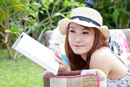 Beautiful asian woman reading her book in the gardenの写真素材
