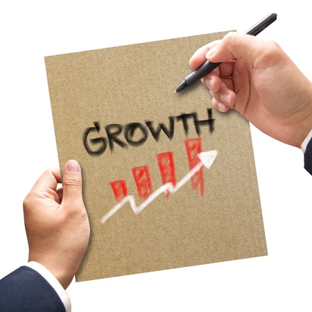 Business hand with pen writing growth on paper conceptの写真素材