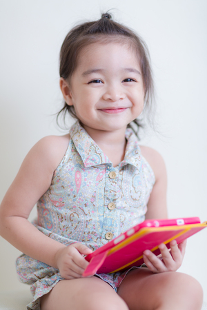 Little Girl playing Tablet Computer at her houseの写真素材