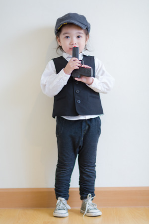 Little girl playing to be a police and holding a pistolの写真素材