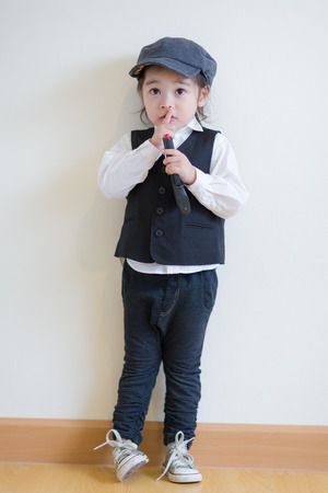 Little girl playing to be a police and holding a pistolの写真素材