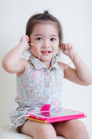 Little Girl playing Tablet Computer at her houseの写真素材