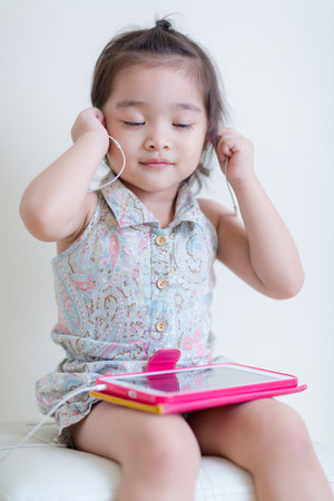 Little Girl playing Tablet Computer at her houseの写真素材