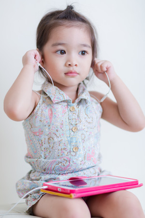 Little Girl playing Tablet Computer at her houseの写真素材