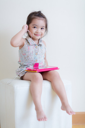 Little Girl playing Tablet Computer at her houseの写真素材