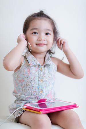 Little Girl playing Tablet Computer at her houseの写真素材