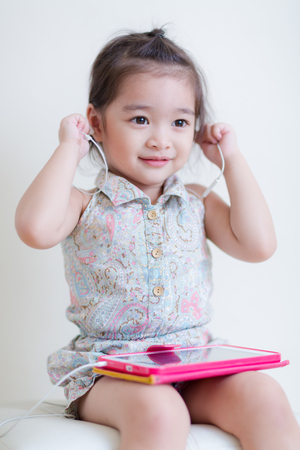 Little Girl playing Tablet Computer at her houseの写真素材