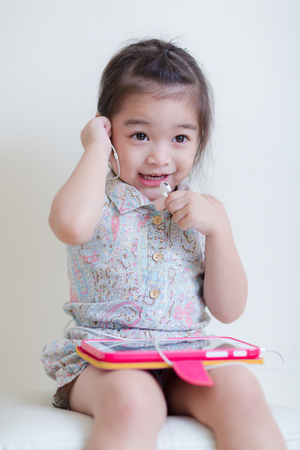 Little Girl playing Tablet Computer at her houseの写真素材