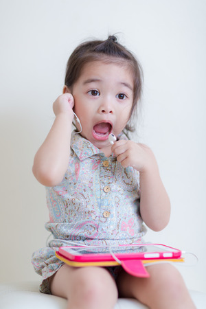 Little Girl playing Tablet Computer at her houseの写真素材