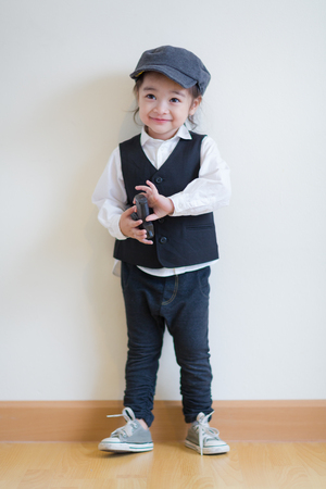 Little girl playing to be a police and holding a pistolの写真素材