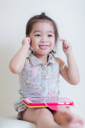 Little Girl playing Tablet Computer at her houseの写真素材