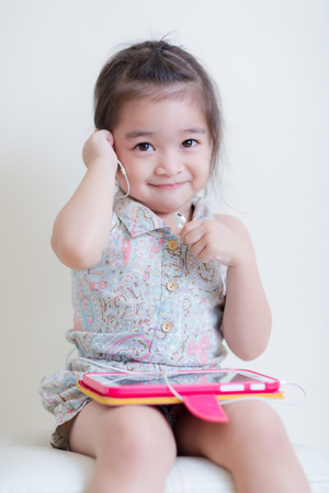 Little Girl playing Tablet Computer at her houseの写真素材