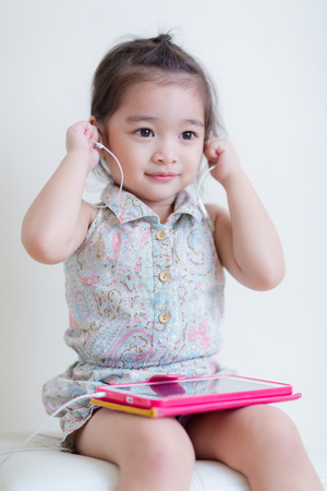 Little Girl playing Tablet Computer at her houseの写真素材