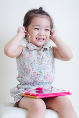 Little Girl playing Tablet Computer at her houseの写真素材
