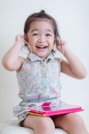 Little Girl playing Tablet Computer at her houseの写真素材
