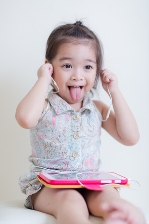 Little Girl playing Tablet Computer at her houseの写真素材