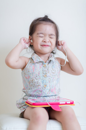 Little Girl playing Tablet Computer at her houseの写真素材