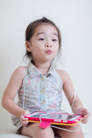 Little Girl playing Tablet Computer at her houseの写真素材