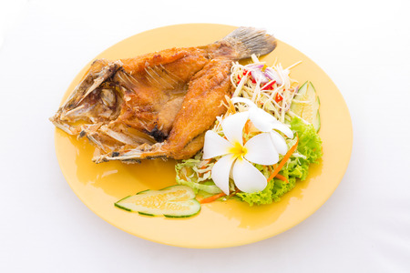 Fried fish with spicy sauce on white plateの写真素材