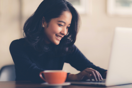 Asian  woman working with her laptop and coffee on desk, Vintage colorの写真素材