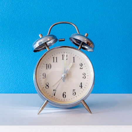 old alarm clock on blue background