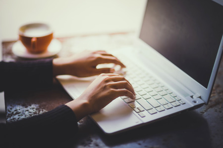 Hand of woman working with her Laptop and Coffee by the sideの写真素材