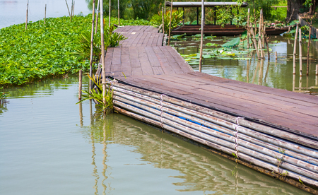 Old brown walkway for strolling across on the water.の写真素材