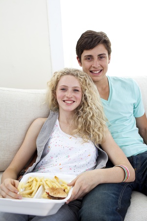Teen couple eating burgers and friesの写真素材