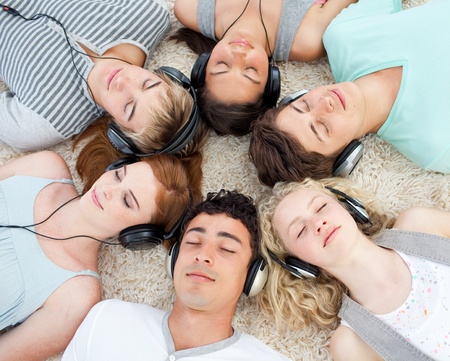 Group of friends listening to music on the floorの写真素材