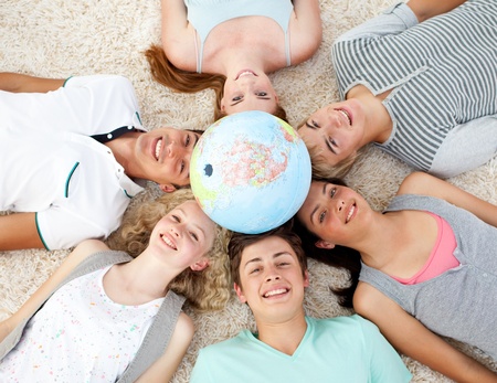 Teenagers on the floor with a terrestrial globe in the centerの写真素材