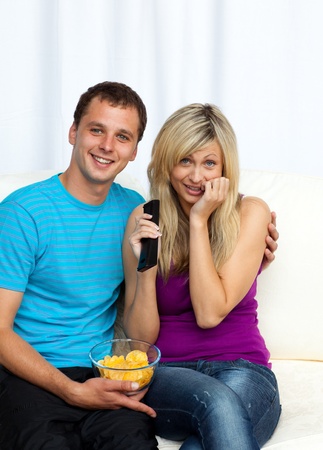 Funny couple watching a television at homeの写真素材