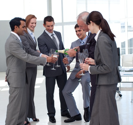 Successful businessman serving Champagne to his colleagues の写真素材