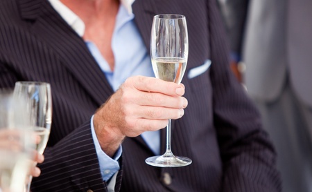 Close-up of a senior businessman holding a glass of Champagneの写真素材