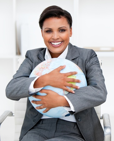 Charismatic businesswoman holding a terrestrial globeの写真素材