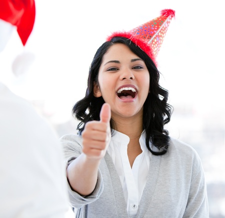 Positive businesswoman doing a thumb-up to celebrate christmasの写真素材