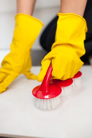 Close-up of a woman cleaning a bathroom's floor 
