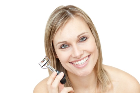 Cheerful woman holding an eyelash curler の写真素材