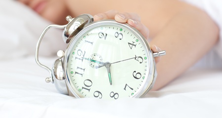 Close-up of a woman holding an alarm clock の写真素材