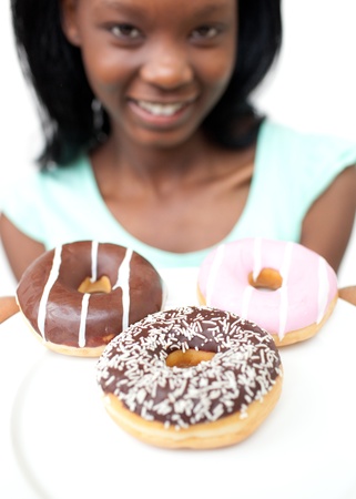 Smiling young woman looking at donuts の写真素材