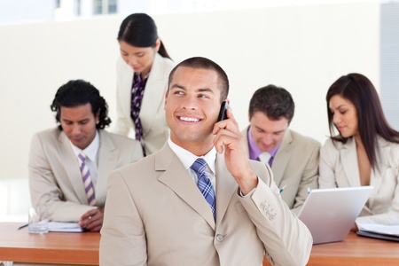 Attractive manager on phone in front of his team の写真素材