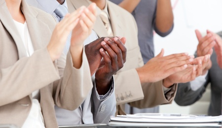 Close-up of business people applauding in a meeting 