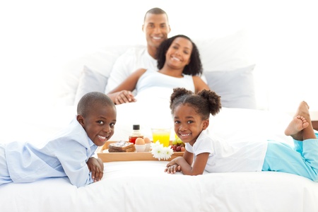 Jolly family having breakfast in the bedroomの写真素材